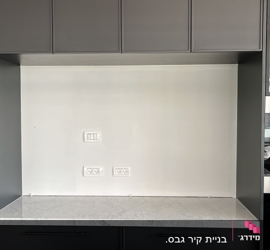 שקעי חשמל ומתגים על קיר לבן במטבח